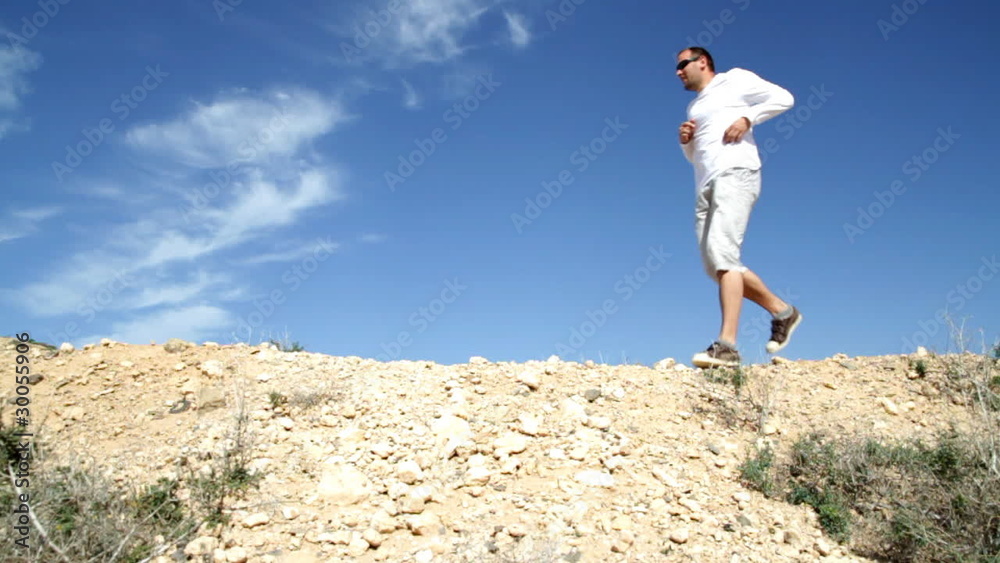 Athletic young man running at the desert, slow motion Athletic young man running at the desert, slow motion