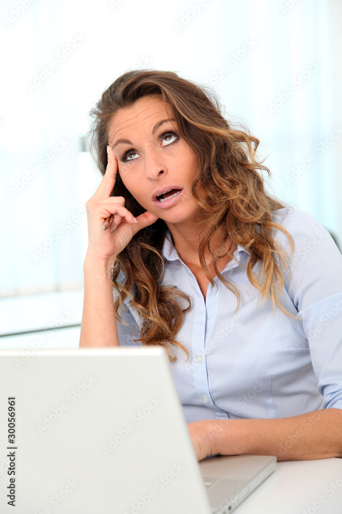 Office worker with desperate look in front of laptop Office worker with desperate look in front of laptop