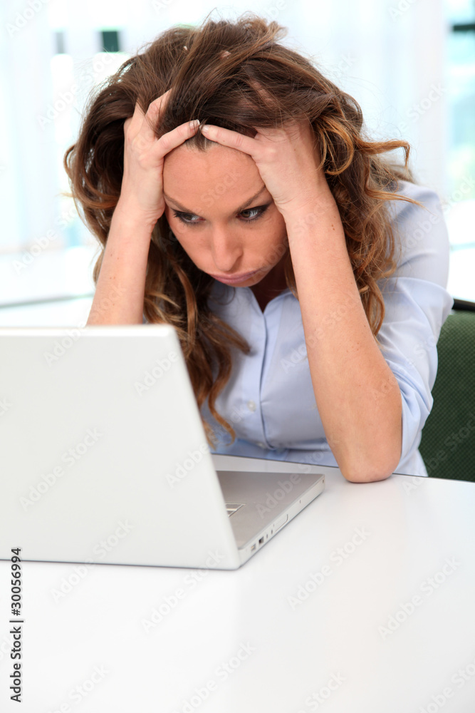 Office worker with desperate look in front of laptop Office worker with desperate look in front of laptop