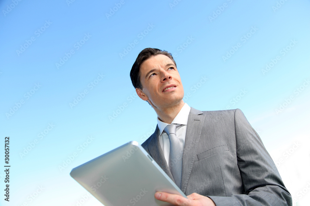 Portrait of businessman working on electronic tablet