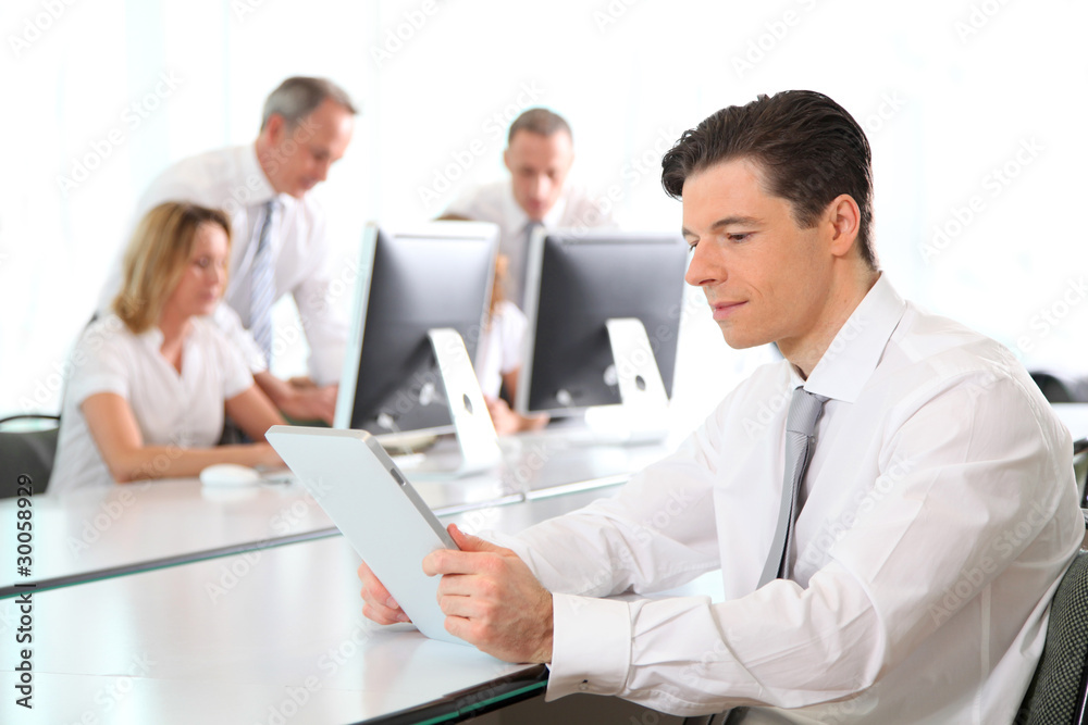 Office worker using electronic tablet in office Office worker using electronic tablet in office