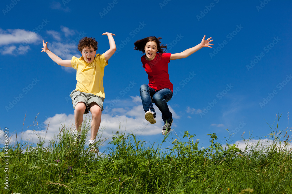 Girl and boy jumping, running against blue sky Girl and boy jumping, running against blue sky