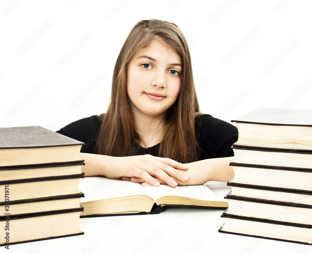 Young girl sitting at the desk and reading book Young girl sitting at the desk and reading book