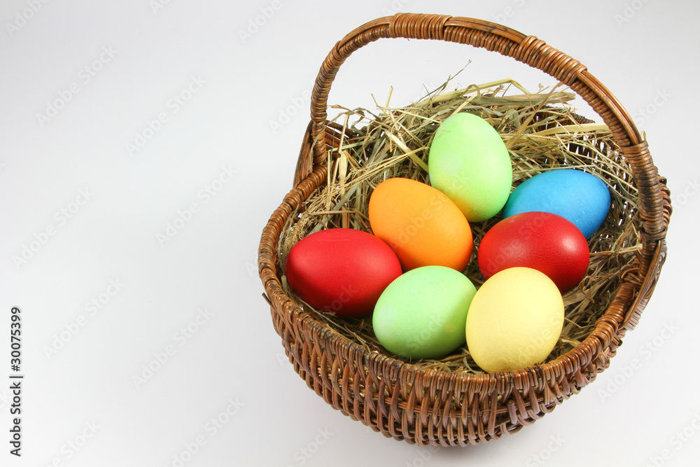 Naklejka premium ein kleiner Korb mit bunten Eiern zum Osterfest