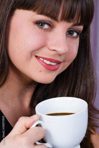 portrait of a beautiful smiling girl with a cup of coffee