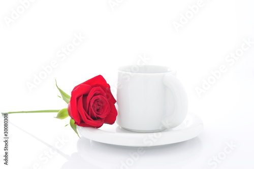 コーヒーカップの横に一輪の赤い薔薇が添えられた写真