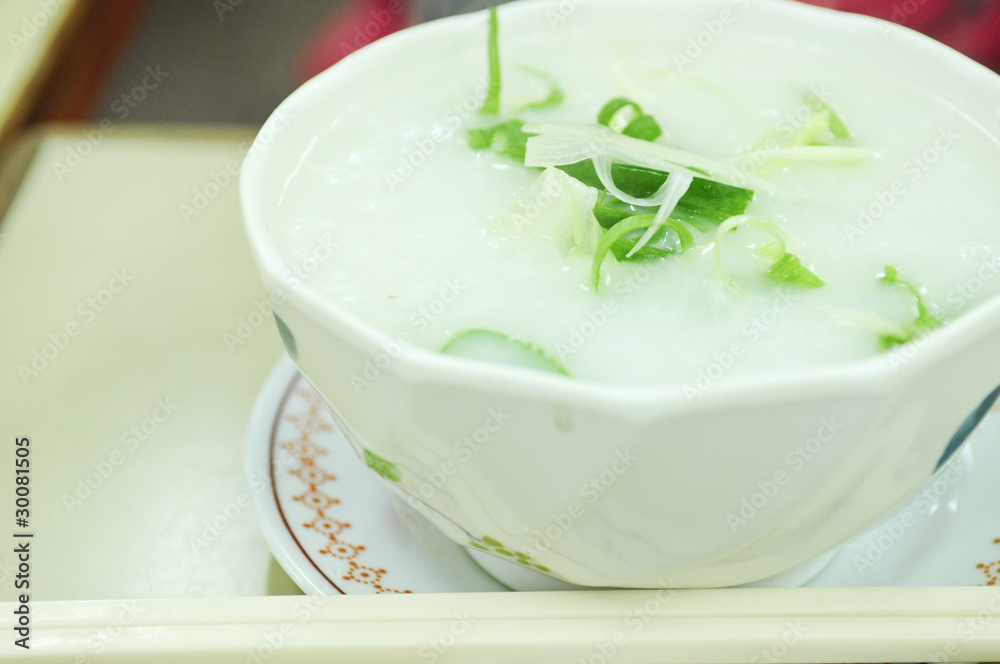 Rice porridge, or jook in white bowl with chopsticks Rice porridge, or jook in white bowl with chopsticks