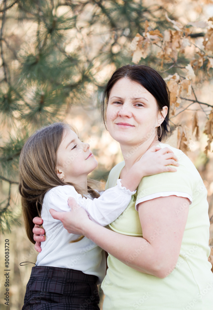 Mother and daughter have fun - beautiful forest in background Mother and daughter have fun - beautiful forest in background