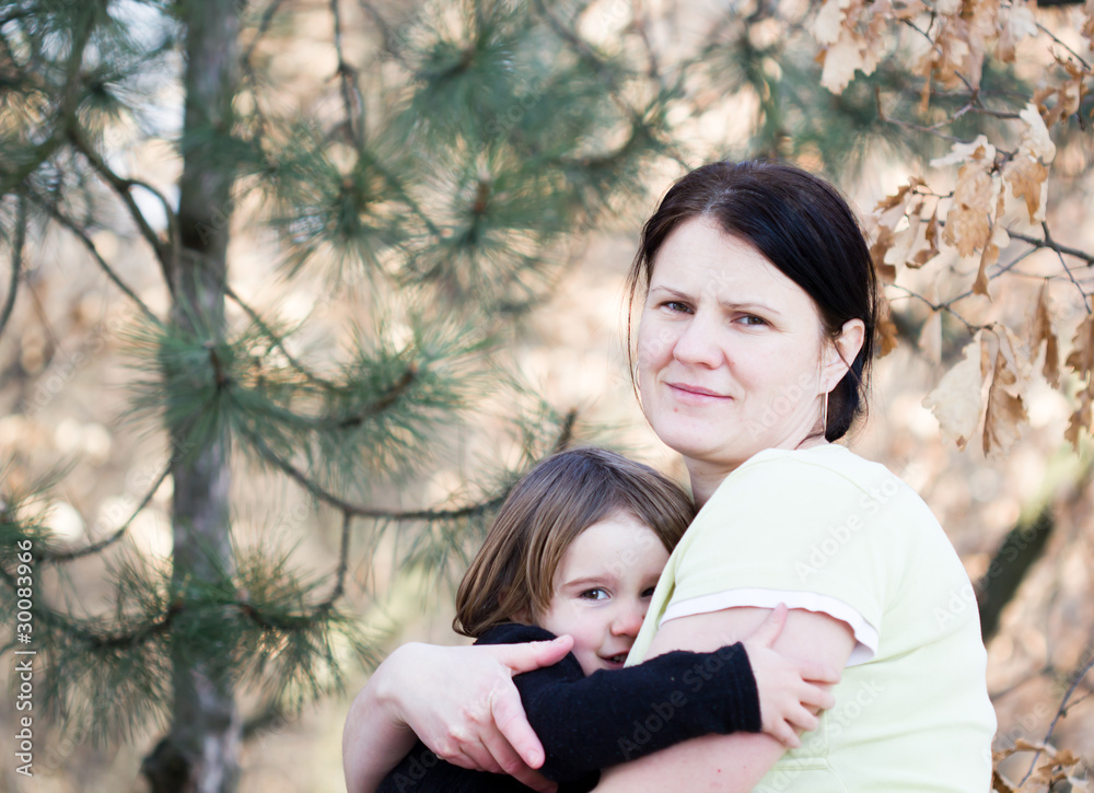 Mother and daughter have fun - beautiful forest in background Mother and daughter have fun - beautiful forest in background