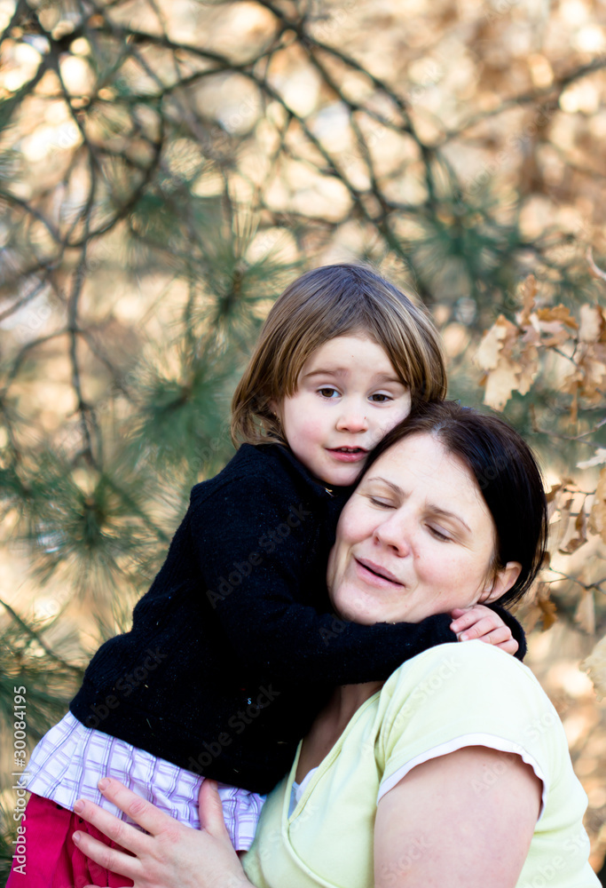 Mother and daughter have fun - beautiful forest in background Mother and daughter have fun - beautiful forest in background