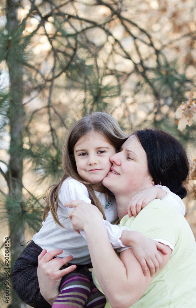 Mother and daughter have fun - beautiful forest in background Mother and daughter have fun - beautiful forest in background