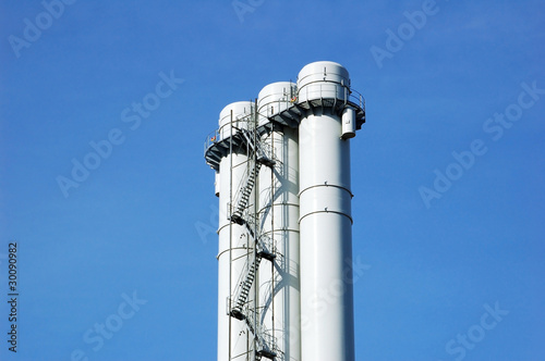 Chimney in an industrial area on blue sky background