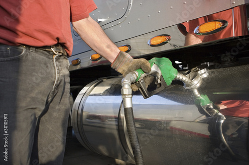 Man fueling Up a Freight Transport Truck photo