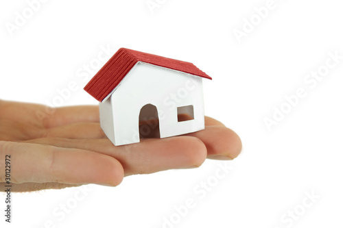 human holding little paper model of village house, isolated