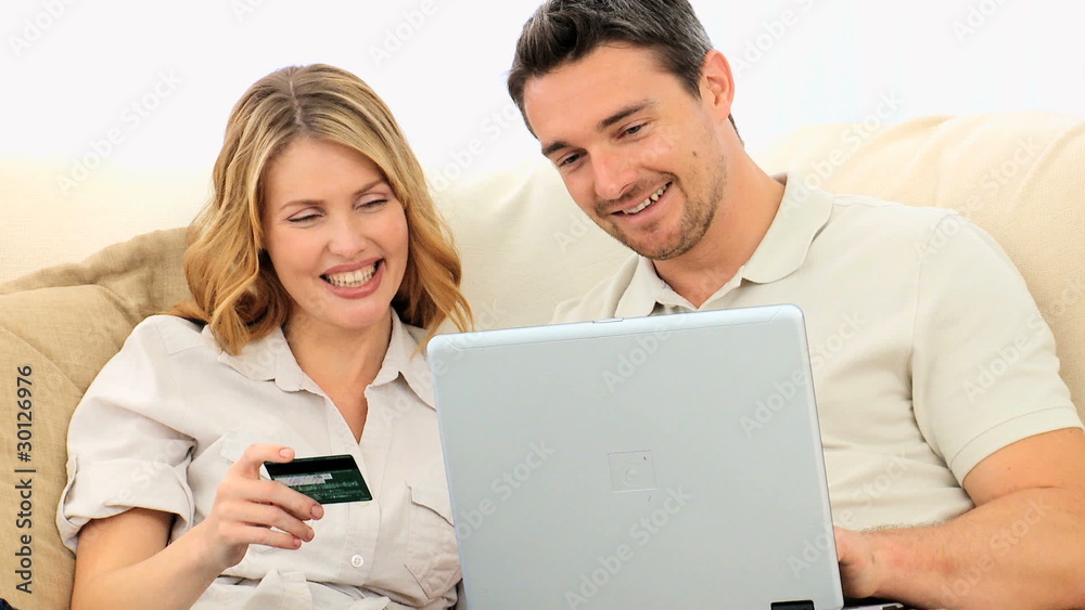 Young couple using a credit card on internet Young couple using a credit card on internet