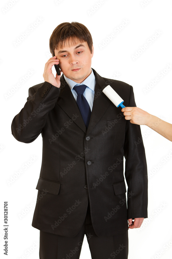 Secretary cleaning chiefs suit while he talking on phone Secretary cleaning chiefs suit while he talking on phone