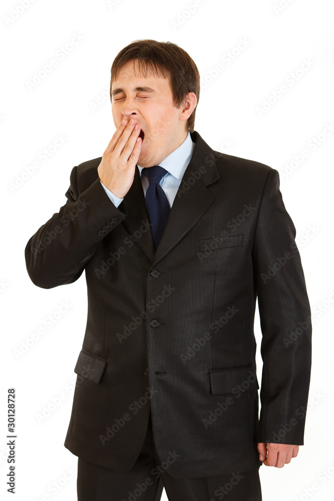 Tired young businessman yawning isolated on white. Tired young businessman yawning isolated on white.