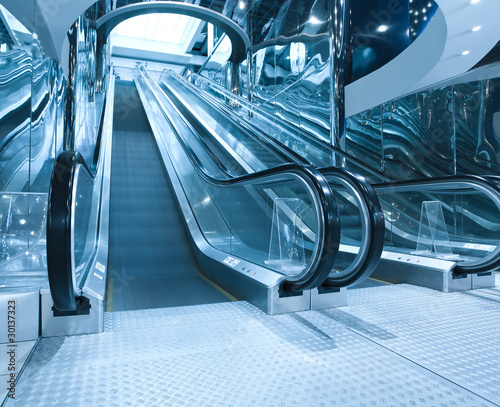 contemporary moving escalator stairs inside business blue hall