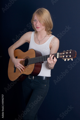 blonde plays an acoustic guitar