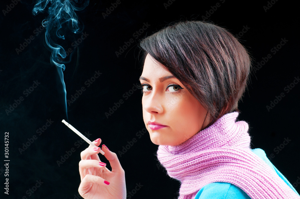 Obraz premium Young girl smoking on black