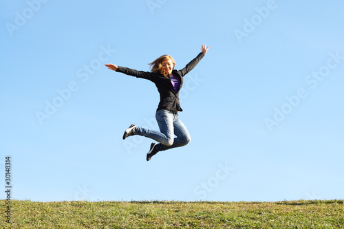 Jumping girl at field in summer. Freedom