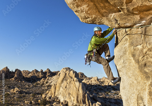 Canvas-taulu Rock climber clinging to a cliff.