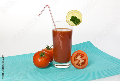 Tomatensaft im Glas mit Tomaten und Zitronen photo