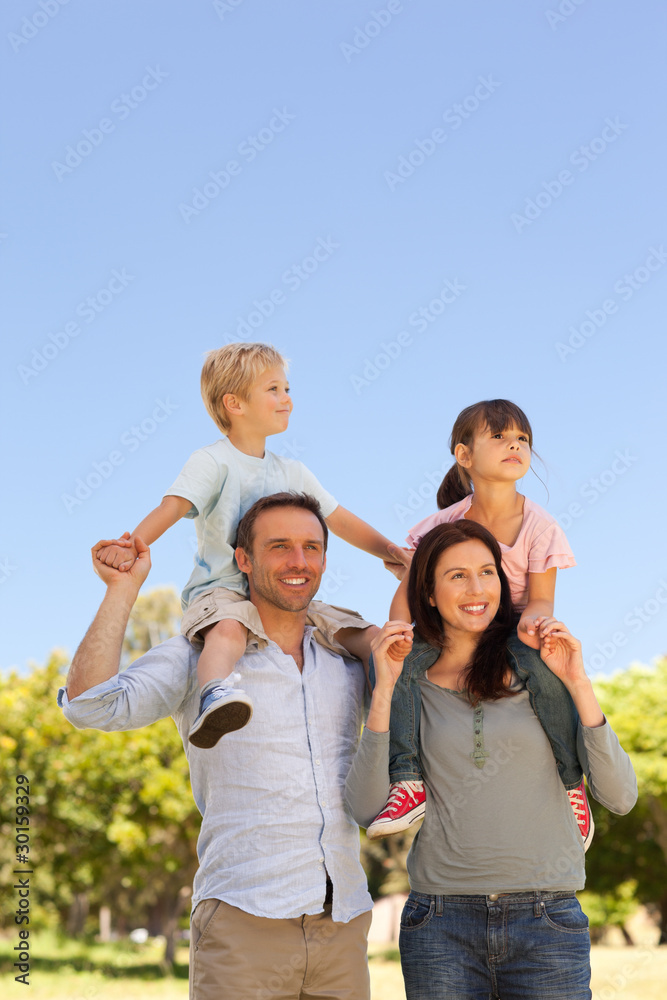 Parents giving children a piggyback Parents giving children a piggyback
