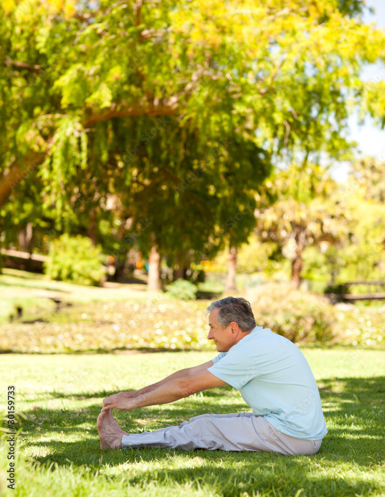 Mature man doing his streches in the park Mature man doing his streches in the park