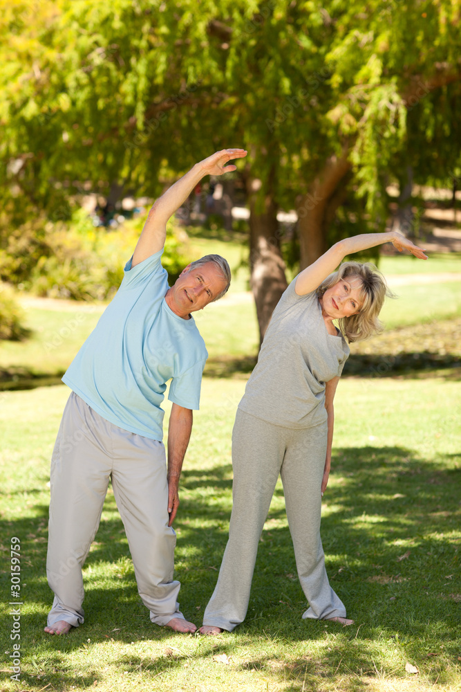 Mature couple doing their streches in the park Mature couple doing their streches in the park