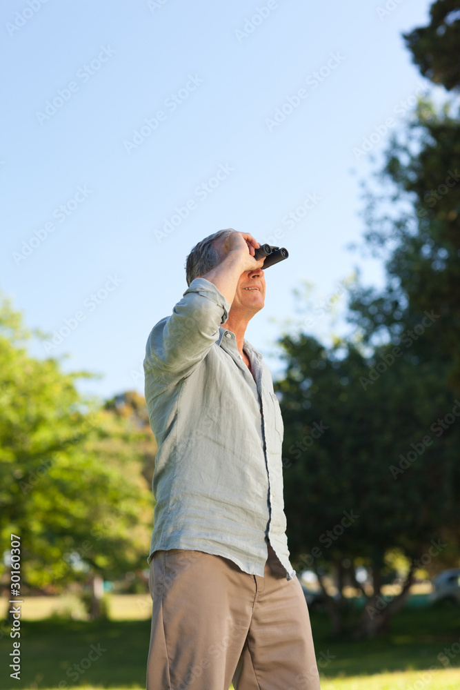 Elderly man looking at the sky with his binoculars Elderly man looking at the sky with his binoculars