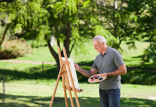 Senior man painting in the garden