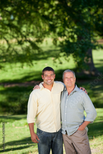 Father and his son looking at the camera in the park