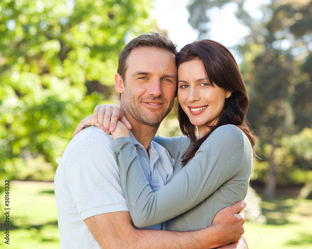 Fototapeta premium Radiant couple hugging in the park