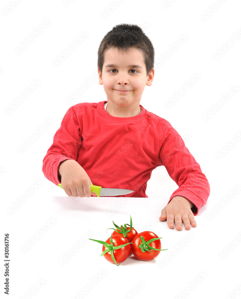 Little chef cutting fresh tomatoes isolated on white background. Little chef cutting fresh tomatoes isolated on white background.