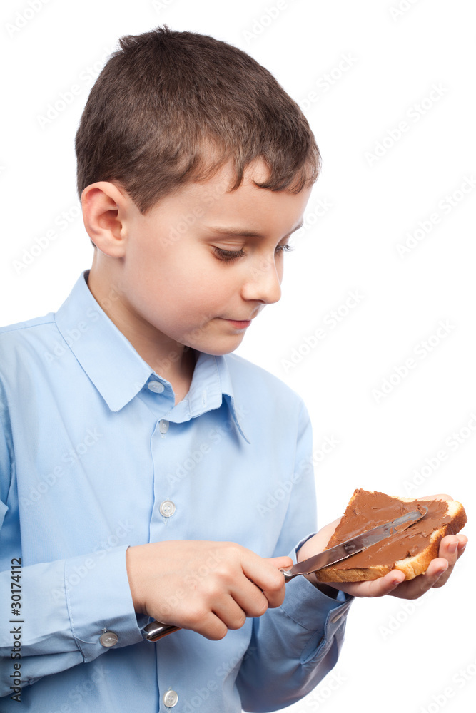 Child spreading peanut butter or chocolate on bread Child spreading peanut butter or chocolate on bread