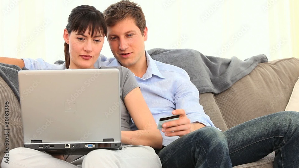 Pretty couple using a credit card on internet Pretty couple using a credit card on internet
