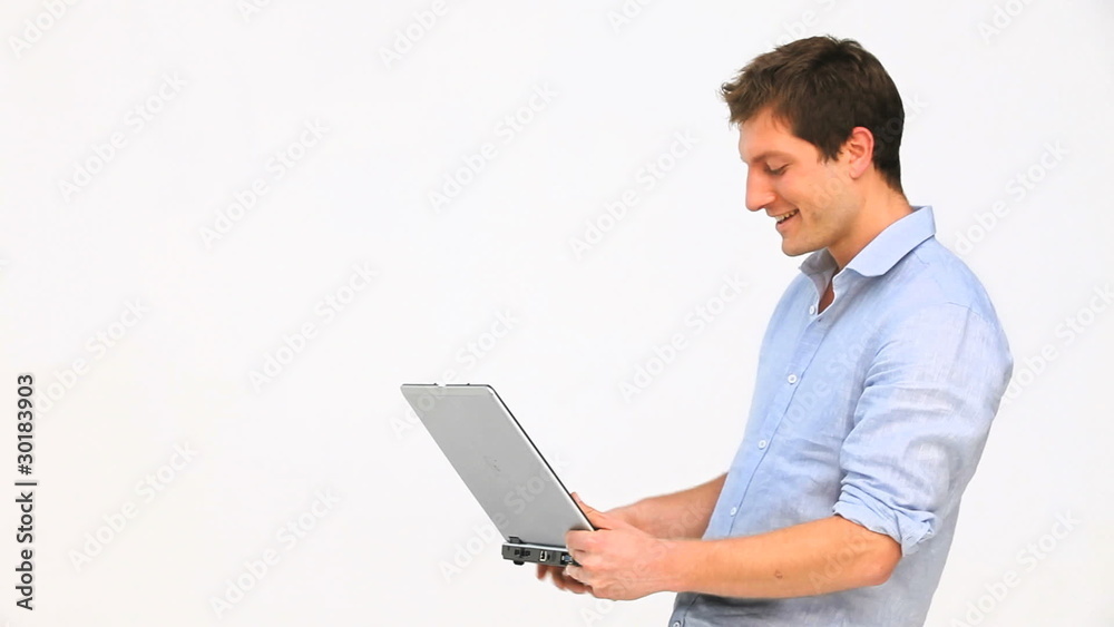 Casual man standing with a laptop Casual man standing with a laptop