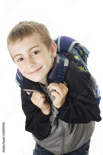 Happy young boy ready for school with his bag