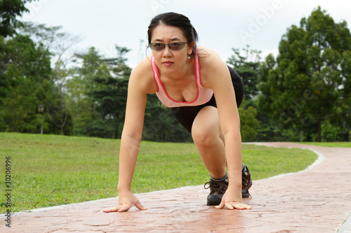 A woman in starting stance ready to run © Adrin Shamsudin