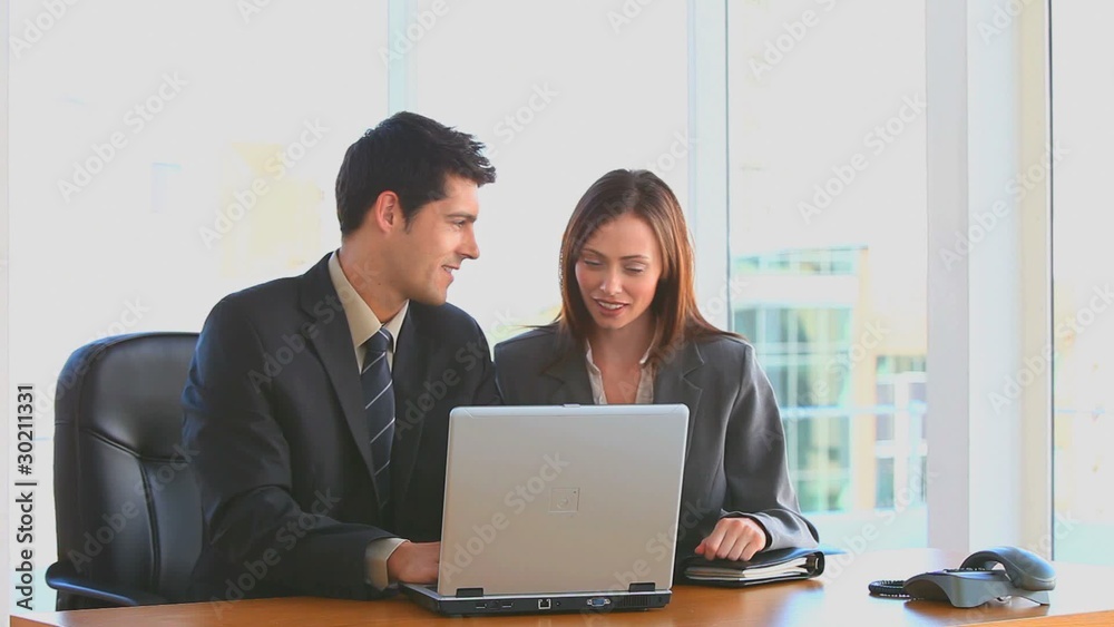 Coworkers looking at their laptop Coworkers looking at their laptop
