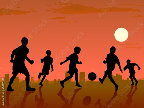 boys playing in soccer on sunset