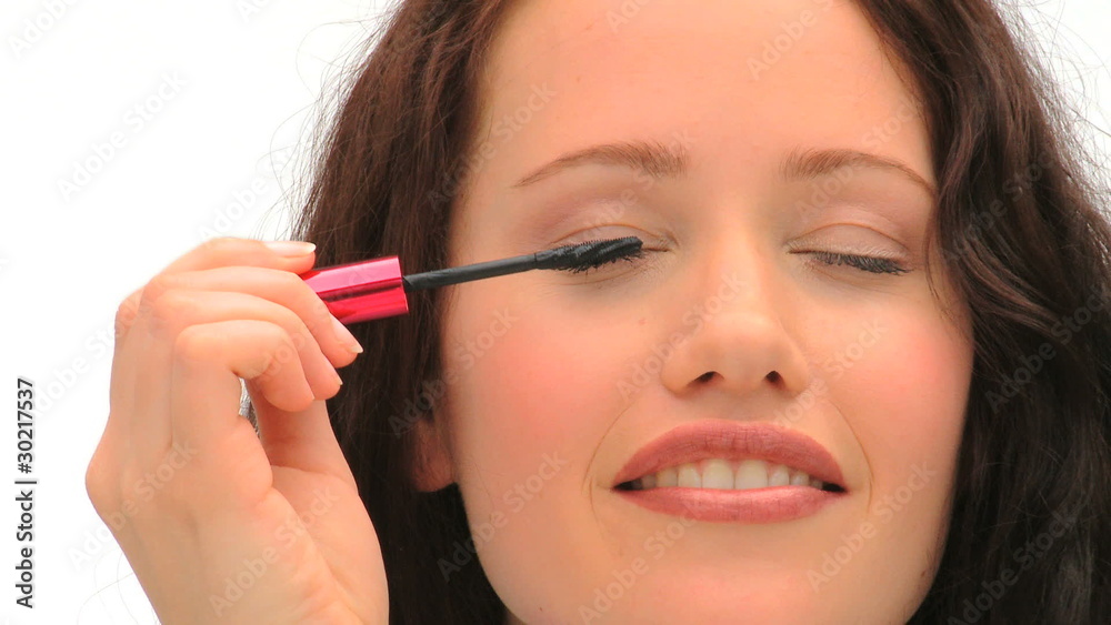 Brown-haired woman putting make-up Brown-haired woman putting make-up