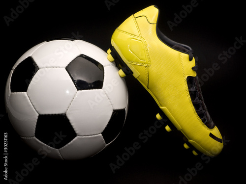Yellow soccer footwear and ball