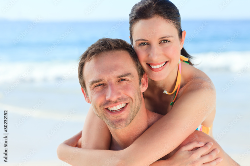 Man having wife a piggyback on the beach Man having wife a piggyback on the beach