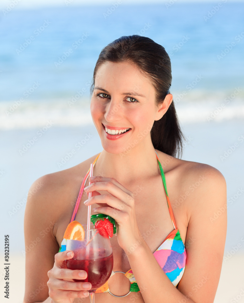 Beautiful woman drinking cocktail on the beach