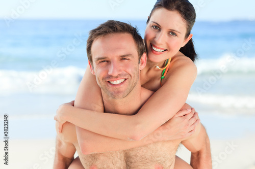 Man having wife a piggyback on the beach