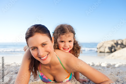 Mother and daughter lying down on the beach © WavebreakMediaMicro