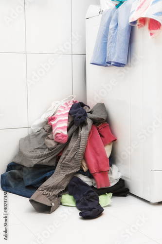 Pile of dirty laundry next to washing machine
