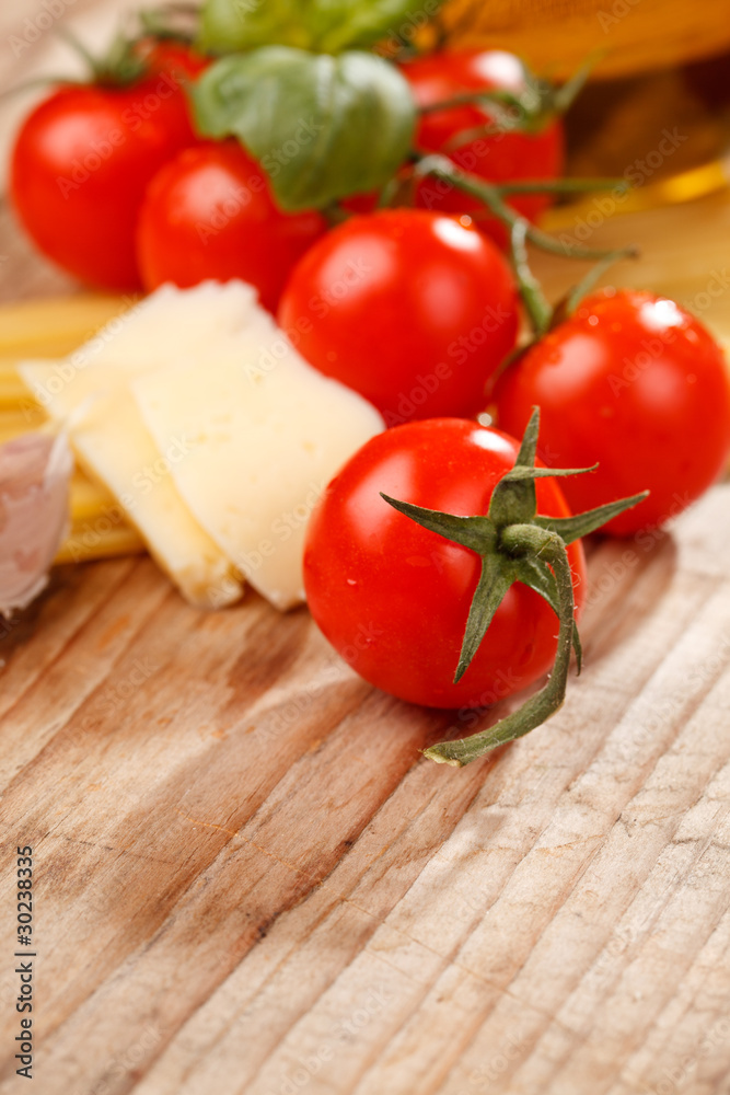 pasta, olive oil and tomatoes on the wood background